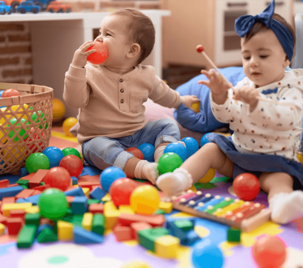 two-toddlers-playing-with-balls-xylophone-sitting-floor-kindergarten