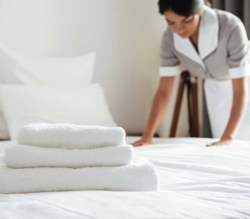 young-hotel-maid-setting-up-pillow-bed