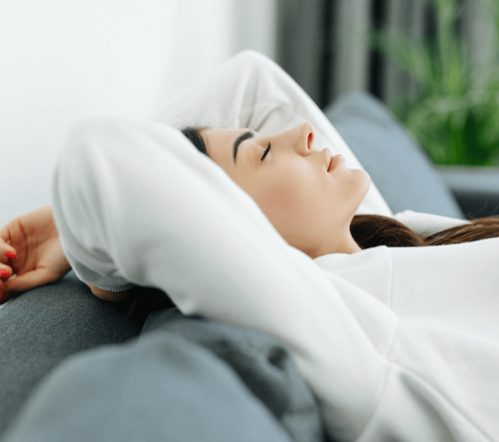 young-woman-relaxing-sitting-couch-with-hands-head-looking-outdoors-through-window-livingroom-home