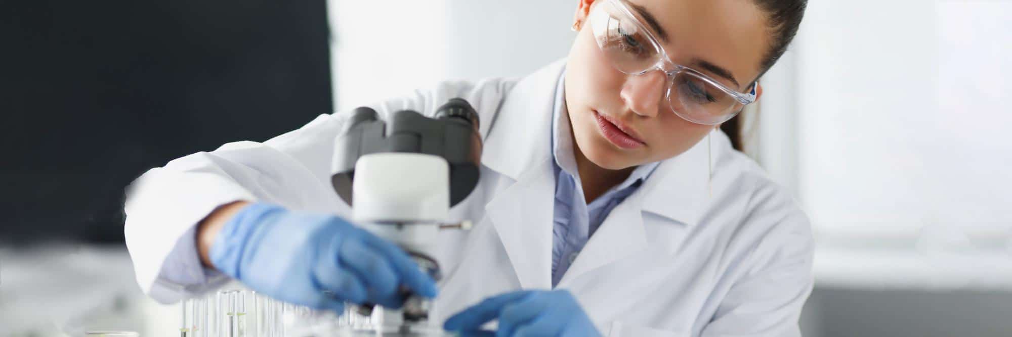 femme-scientifique-chimiste-dans-lunettes-protection-mettant-lame-verre-au-microscope-laboratoire